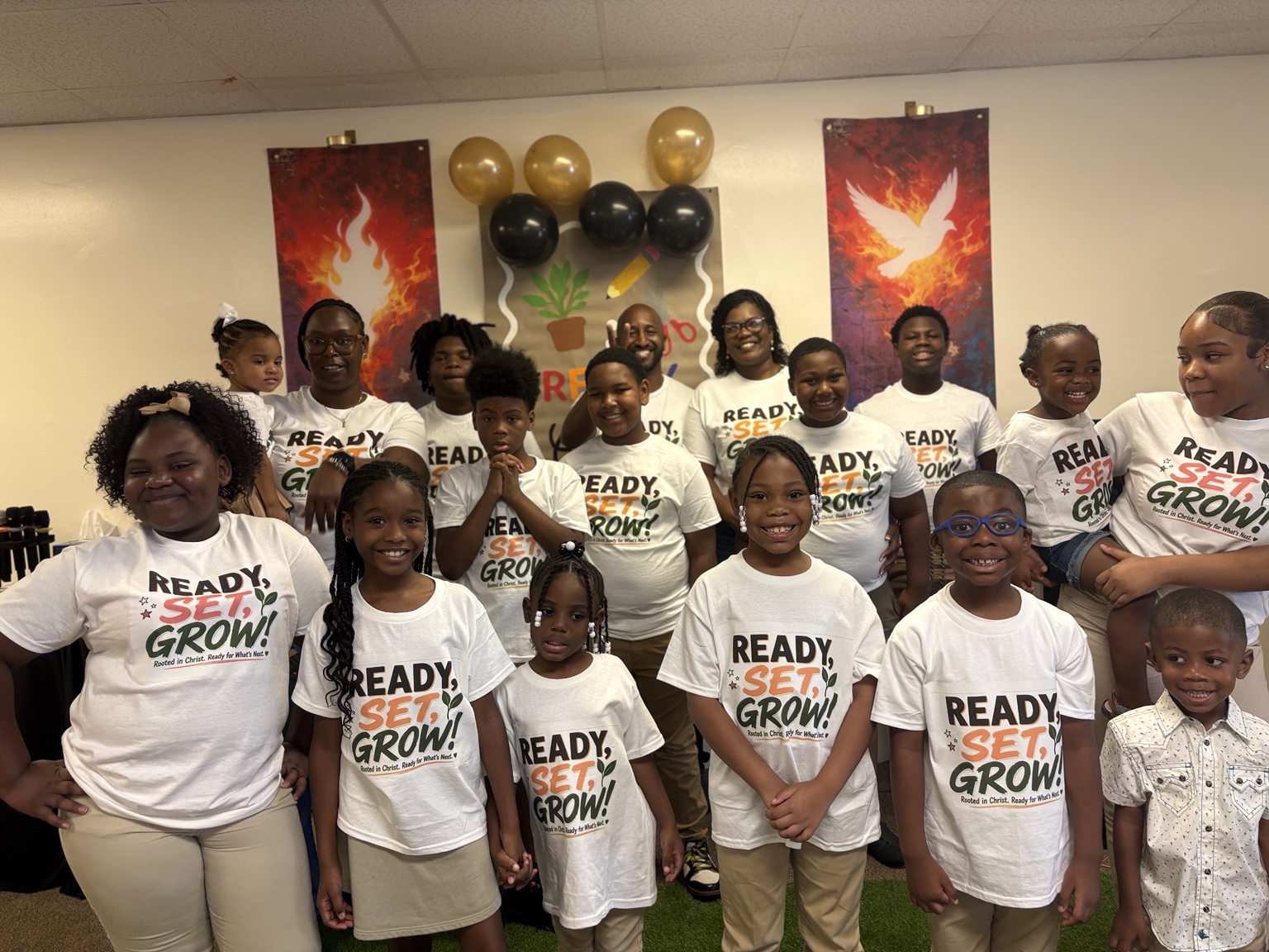 Children and adults wearing Ready, Set, Grow shirts together at The Meeting Place