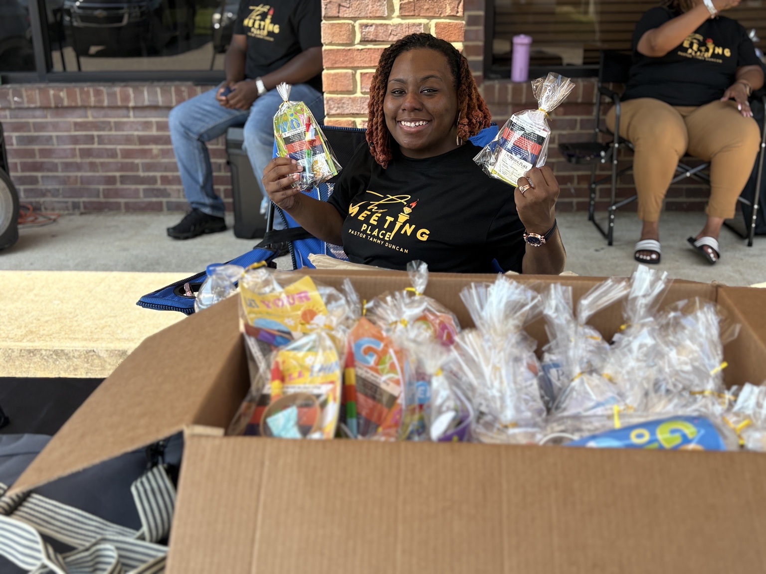 A ministry volunteer holding gift bags prepared for community members