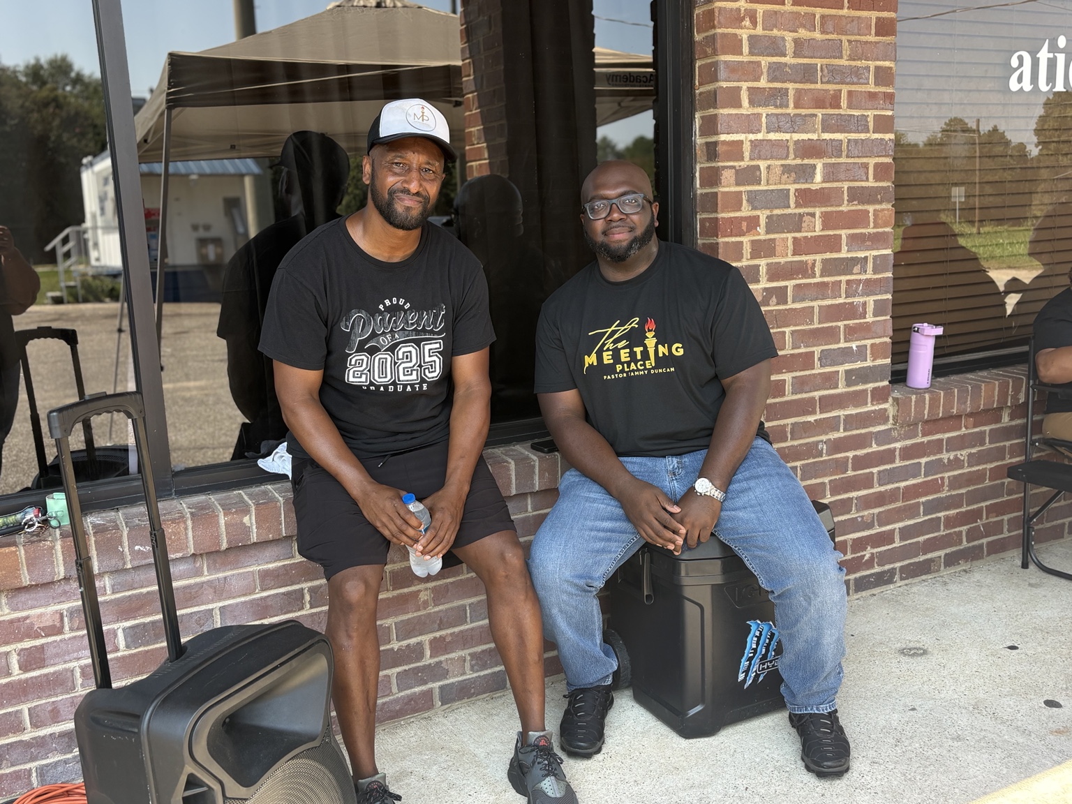 Two men supporting a community outreach gathering