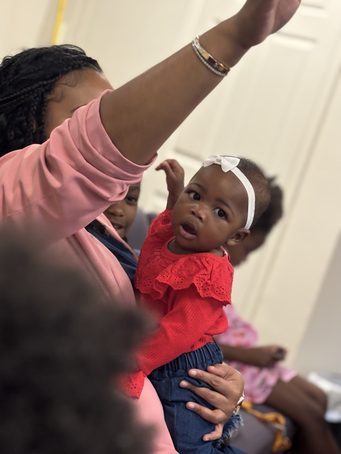 A woman holding a young child during church worship