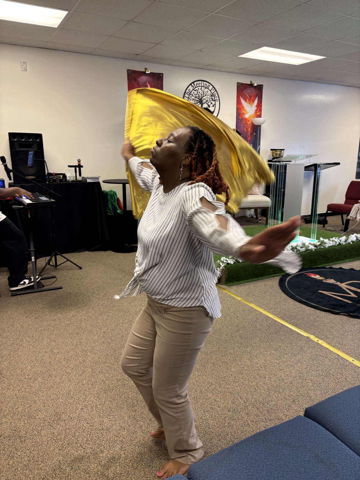 A worshipper dancing with a gold worship flag